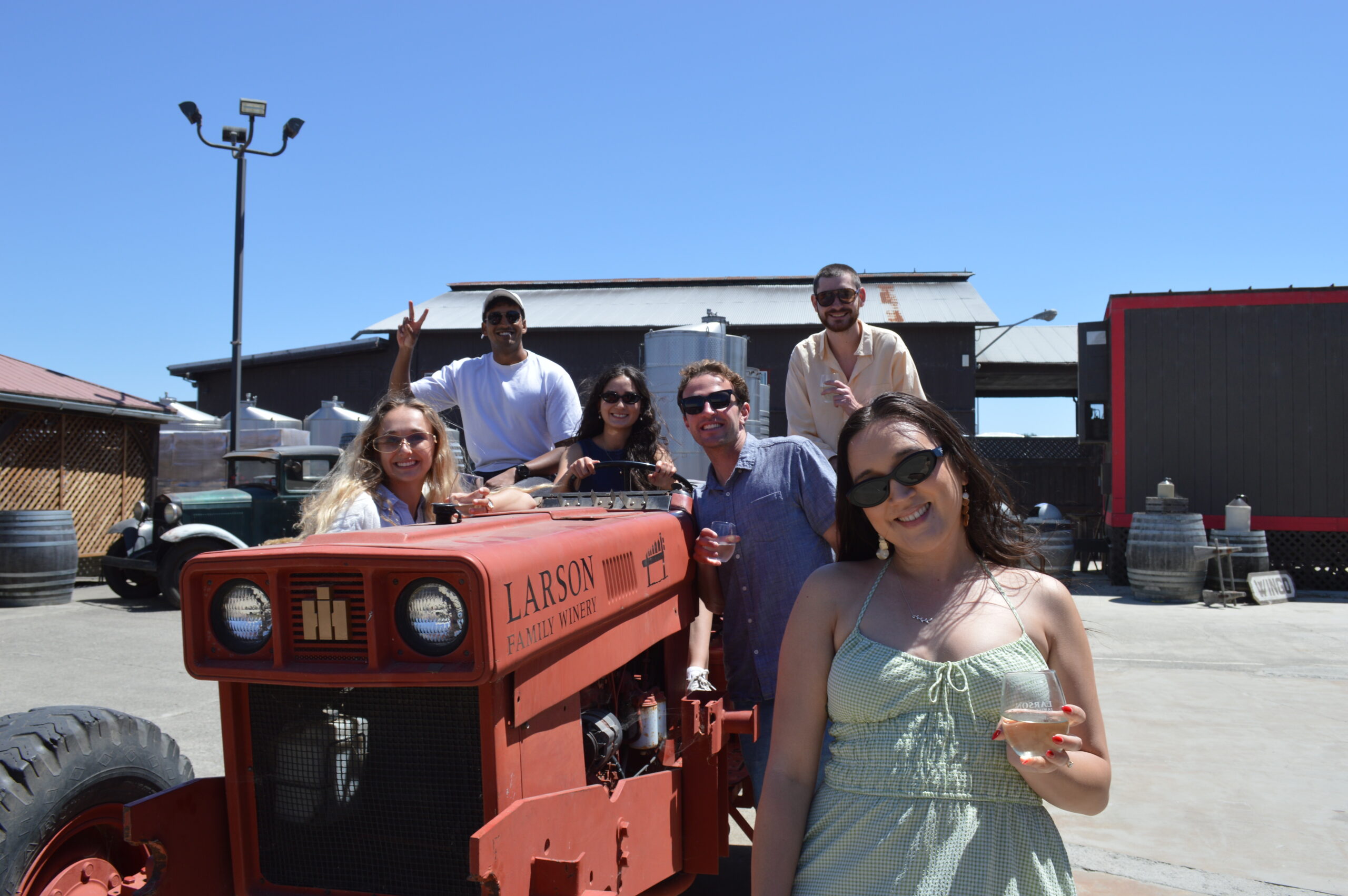 Group riding a vintage Larson Family Winery tractor at the estate