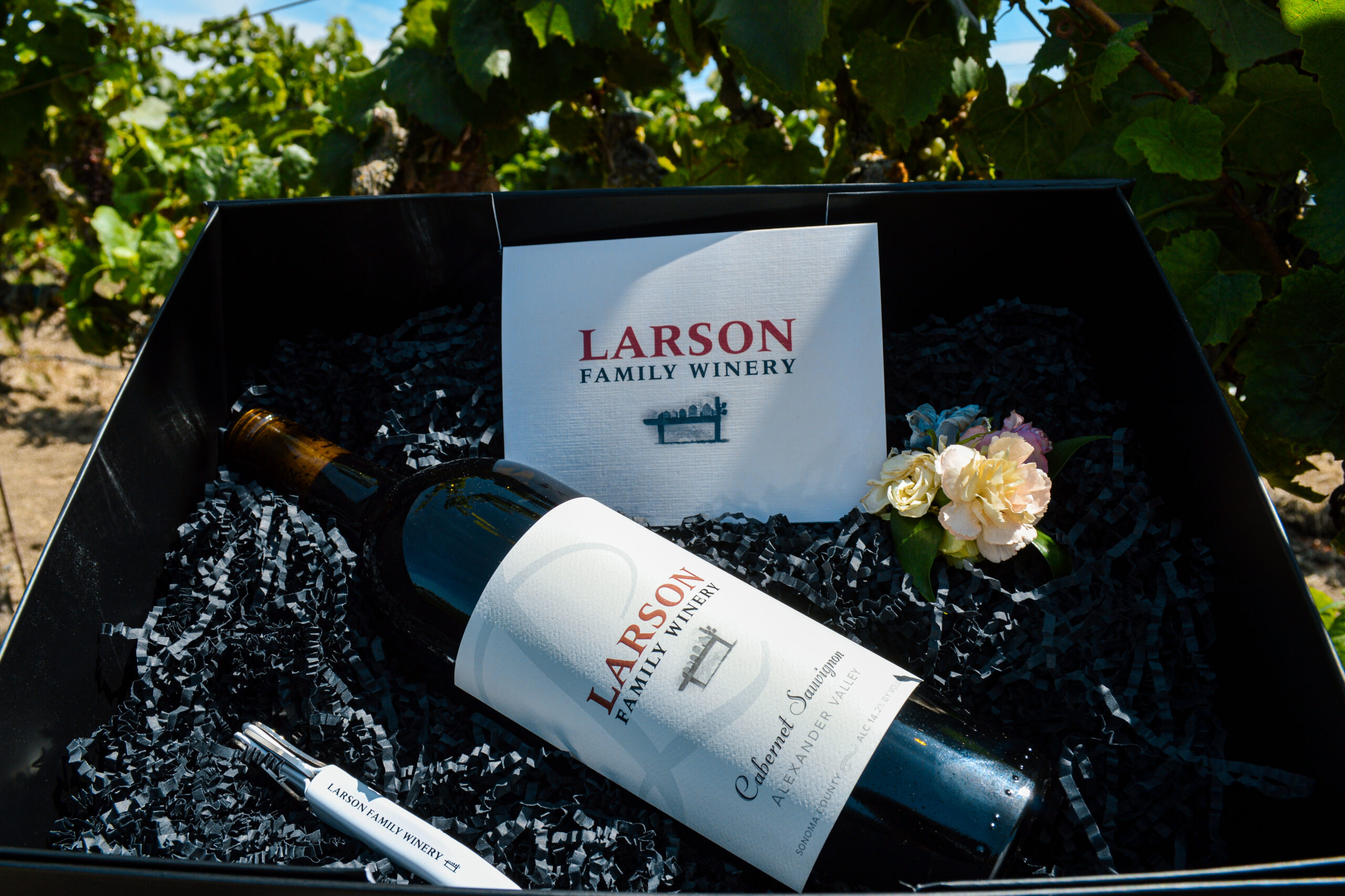 Larson Family Winery corporate gift box with estate Cabernet Sauvignon, branded corkscrew, and custom note among black crinkle fill